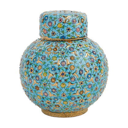 A round ceramic jar with a lid, featuring a hand-painted floral pattern in turquoise, lavender, and gold colors on a glossy turquoise background.