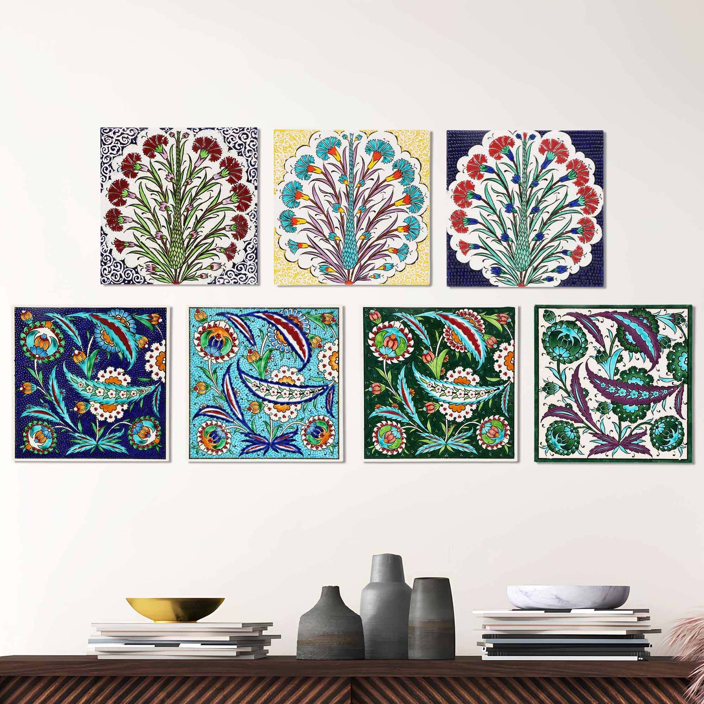 Colorful floral and abstract ceramic tiles on a white wall above a wooden shelf.