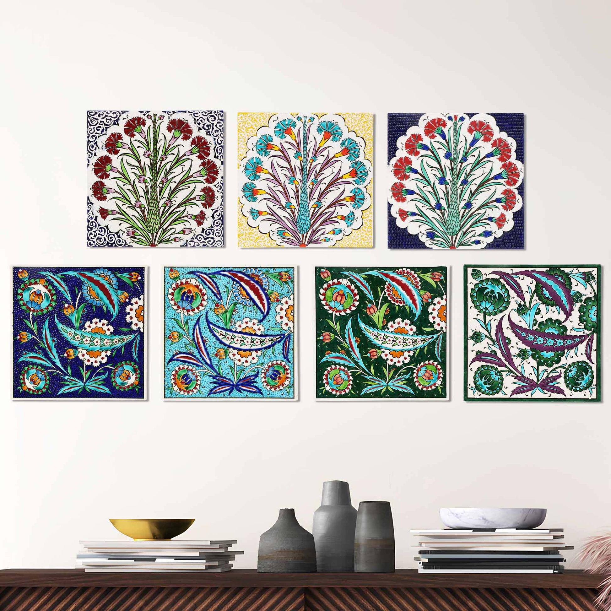 Colorful floral and abstract ceramic tiles on a white wall above a wooden shelf.