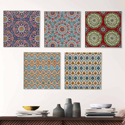 Set of five colorful patterned ceramic tile wall art pieces on a white wall above a wooden shelf with decorative items.