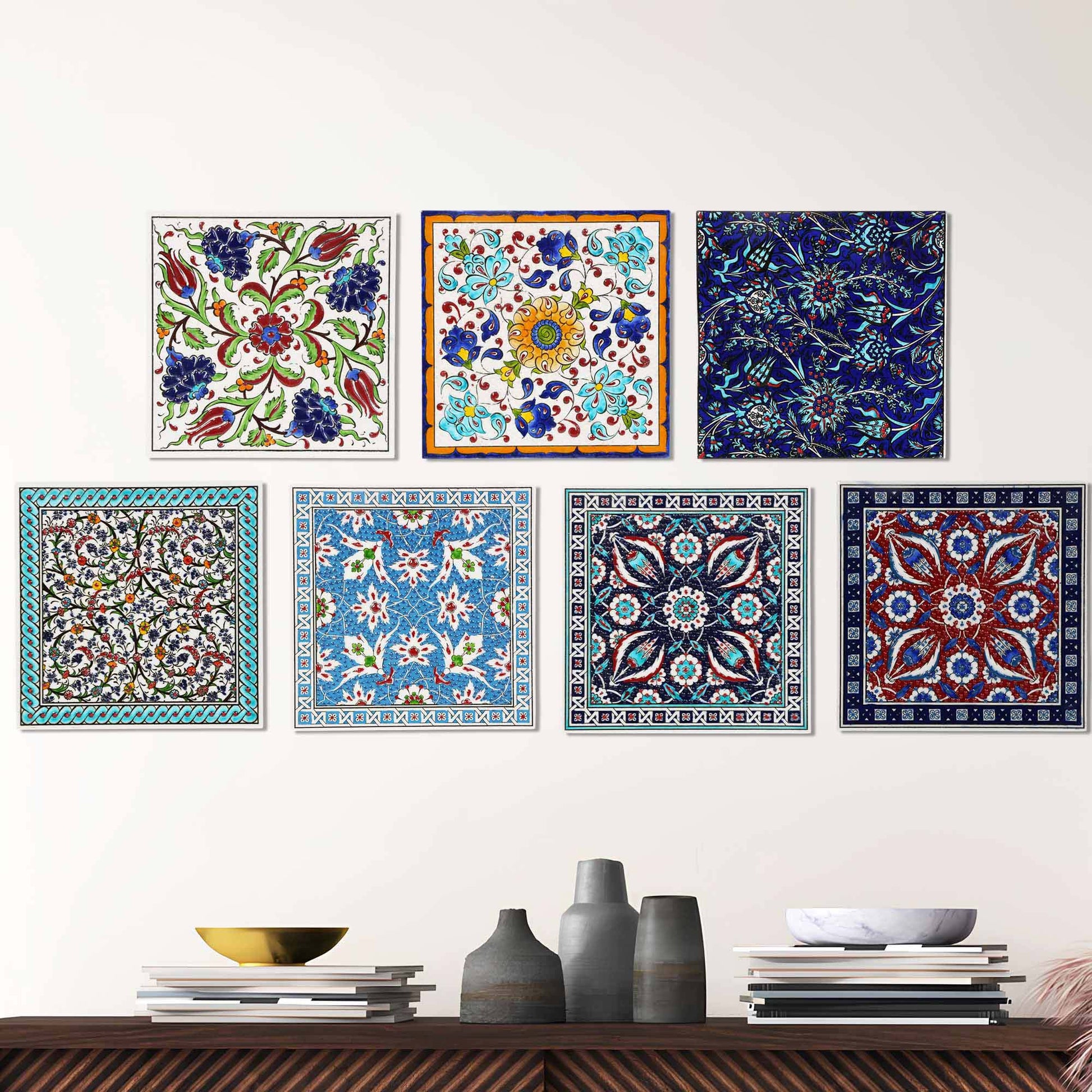 Set of colorful square ceramic tile wall art pieces on a white wall above a wooden shelf.