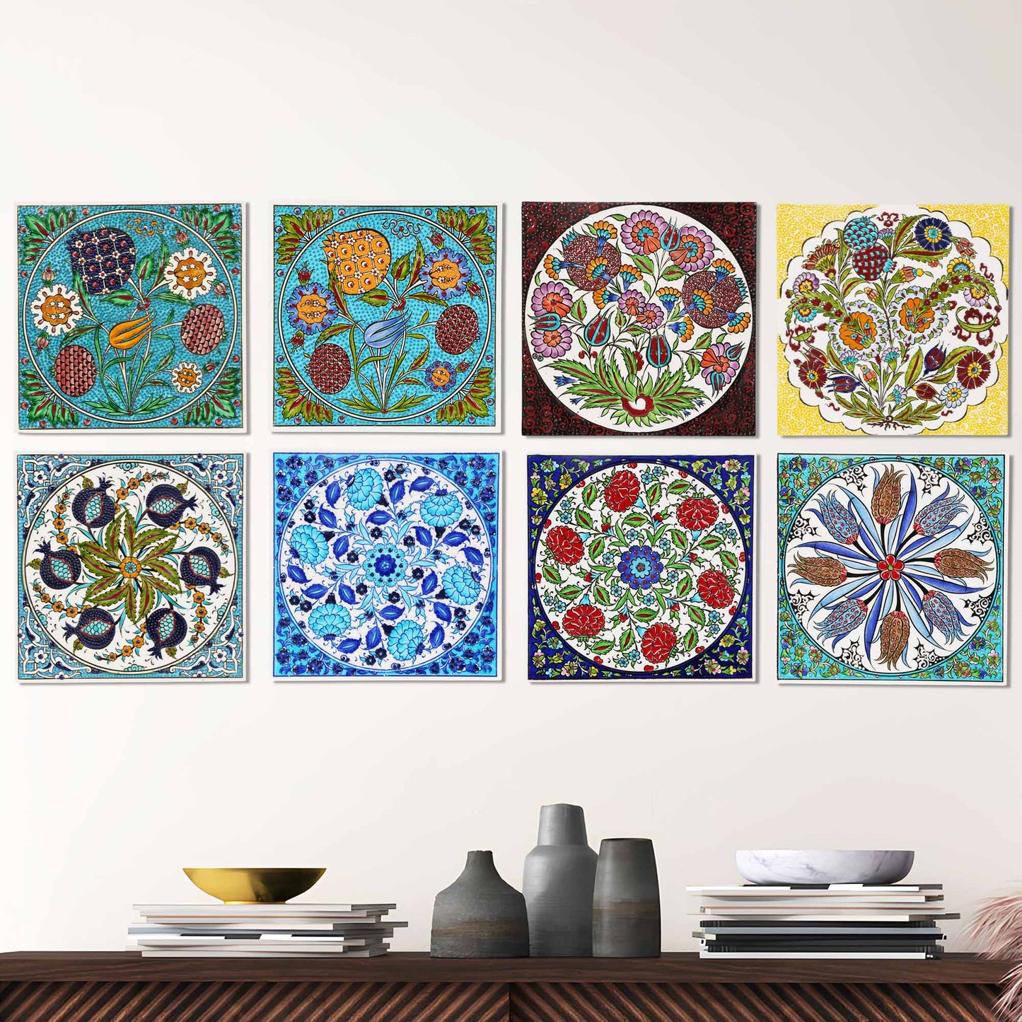 Set of colorful floral and geometric ceramic tiles on a wall above a wooden shelf with decorative items.