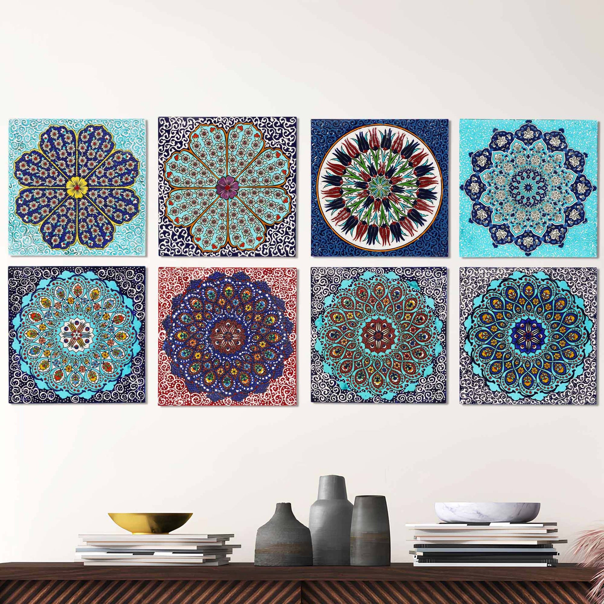 Set of colorful mandala-style ceramic tiles on a white wall above a wooden shelf with decorative items.