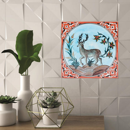 Decorative ceramic tile with deer design on a tiled wall with plant decor.