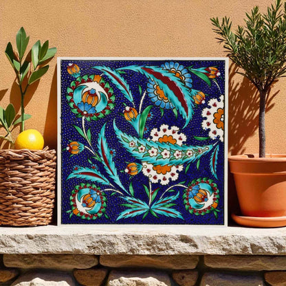 Decorative ceramic tile on a stone ledge with plants in the background