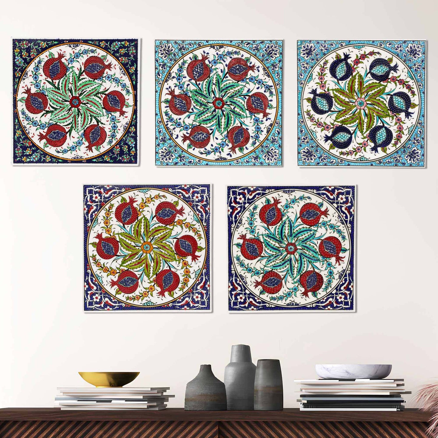 Colorful floral and pomegranate designs ceramic tiles on a wall above a wooden shelf with decorative items.