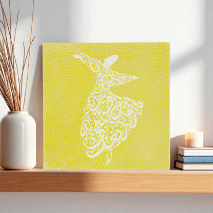 Decorative wall tile with a white abstract design on a yellow background, placed on a shelf.