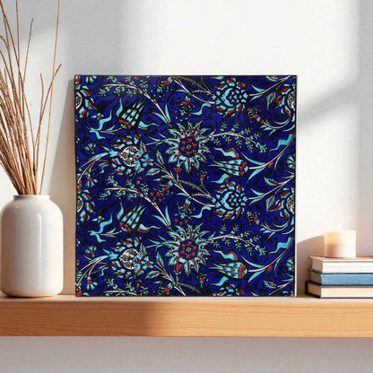 Ceramic tile with a blue floral pattern on a wooden shelf.