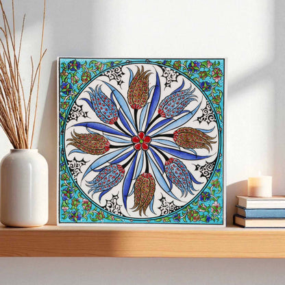 Decorative ceramic tile with floral pattern on a shelf with books and a candle
