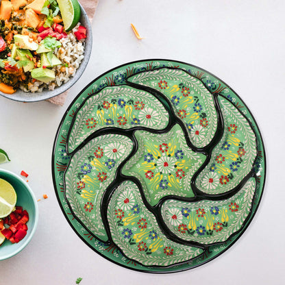 Decorative green snack serving tray set with floral patterns on a white surface with bowls of food.
