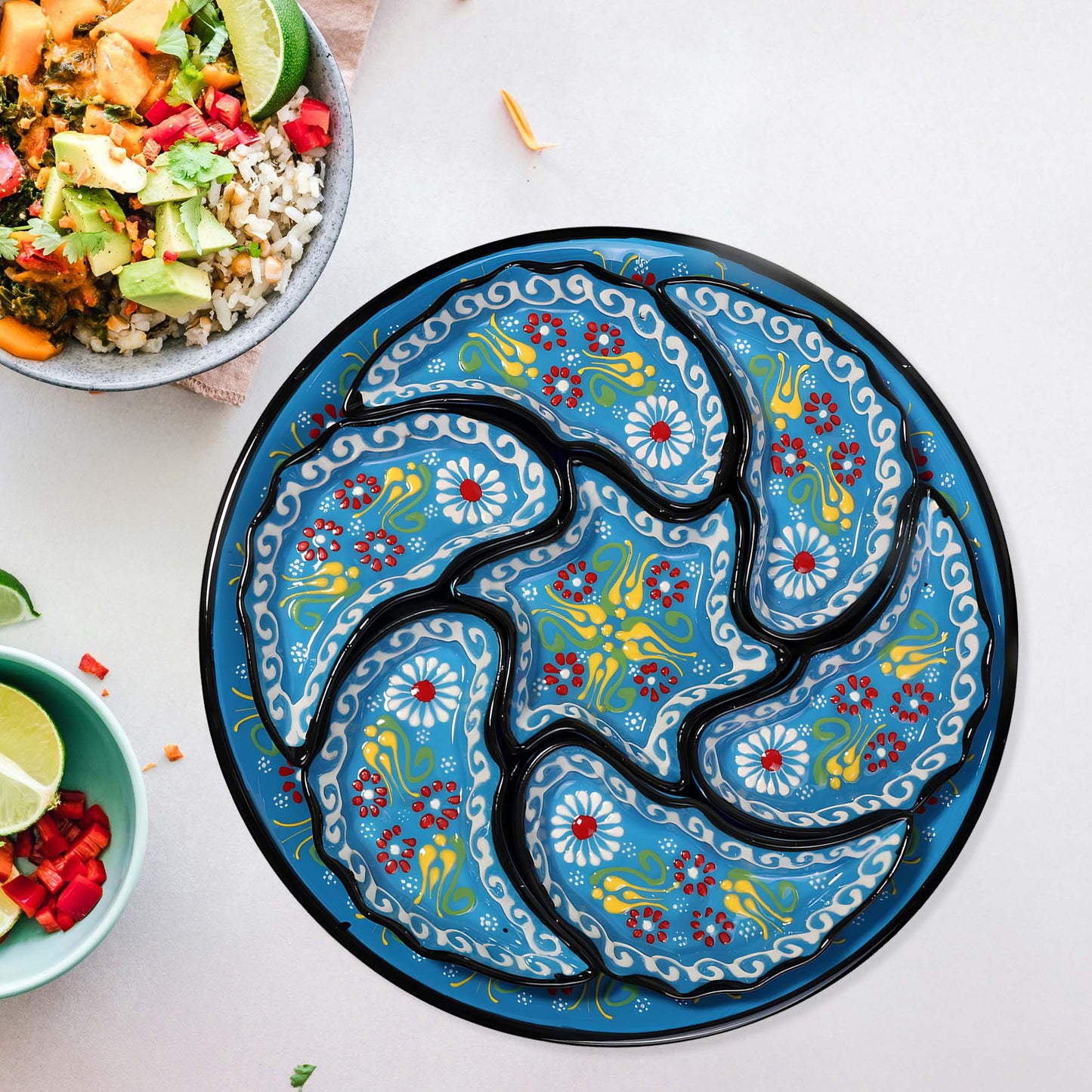 Decorative snack serving tray set with floral patterns on a white surface with bowls of food.