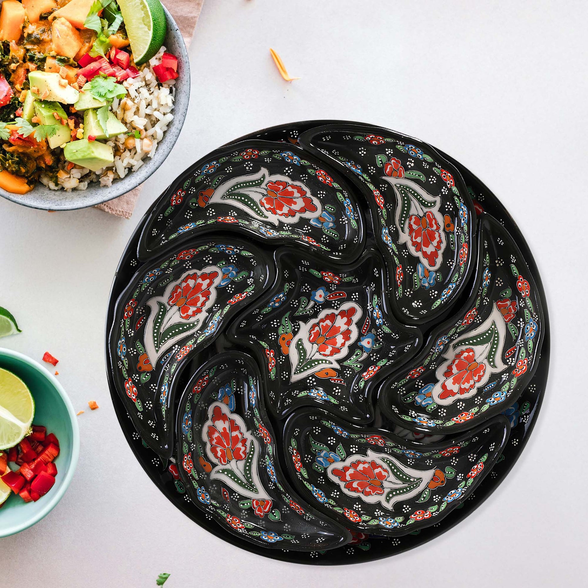 Decorative black snack serving trays with floral patterns on a white surface