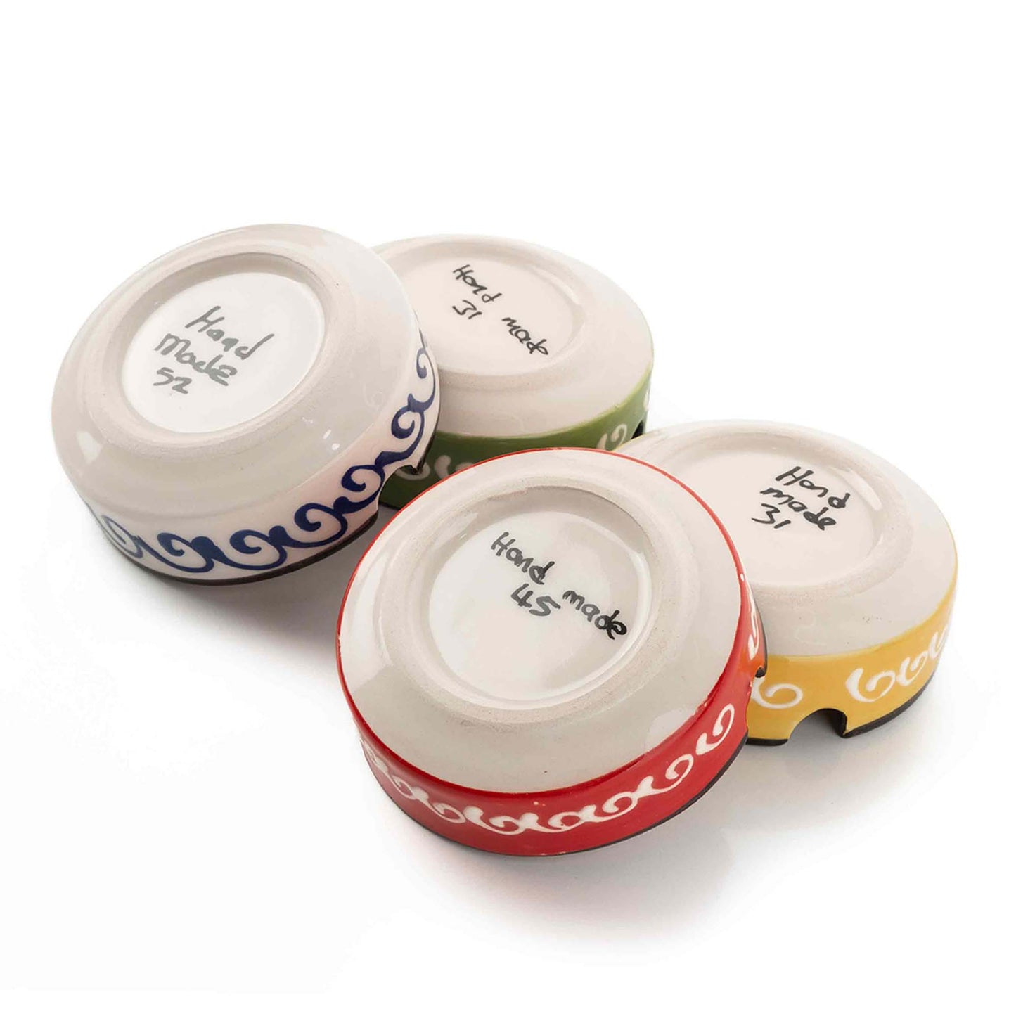 Four small ceramic ashtrays with colorful designs and 'Hand Made' text on a white background