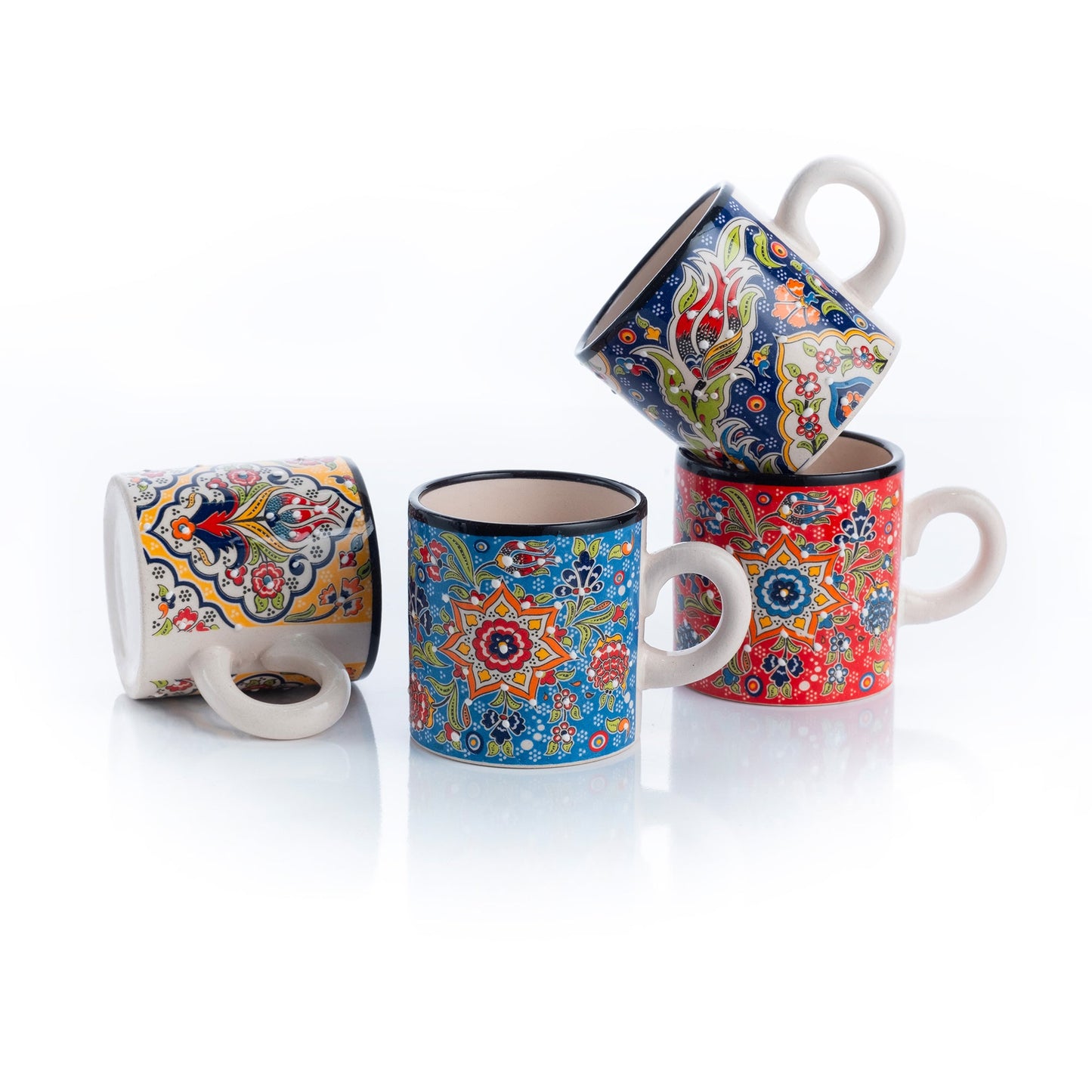 A set of four colorful ceramic espresso cups with floral and geometric patterns.