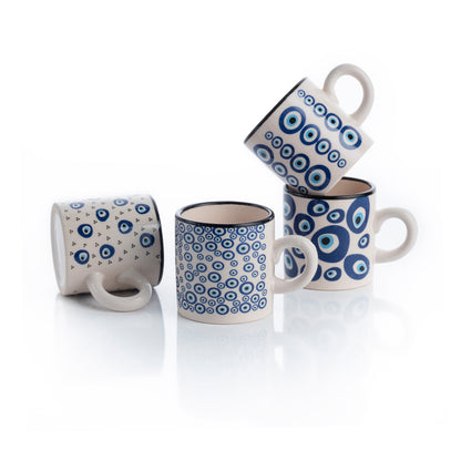 A set of four ceramic espresso cups with a geometric blue and white pattern on a white background, scattered in a stacked layout.