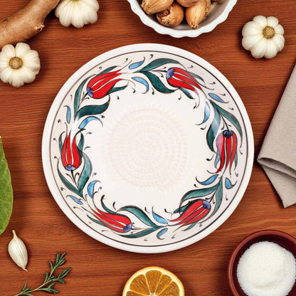 Decorative ceramic garlic grater bowl with floral design on a wooden table with ingredients
