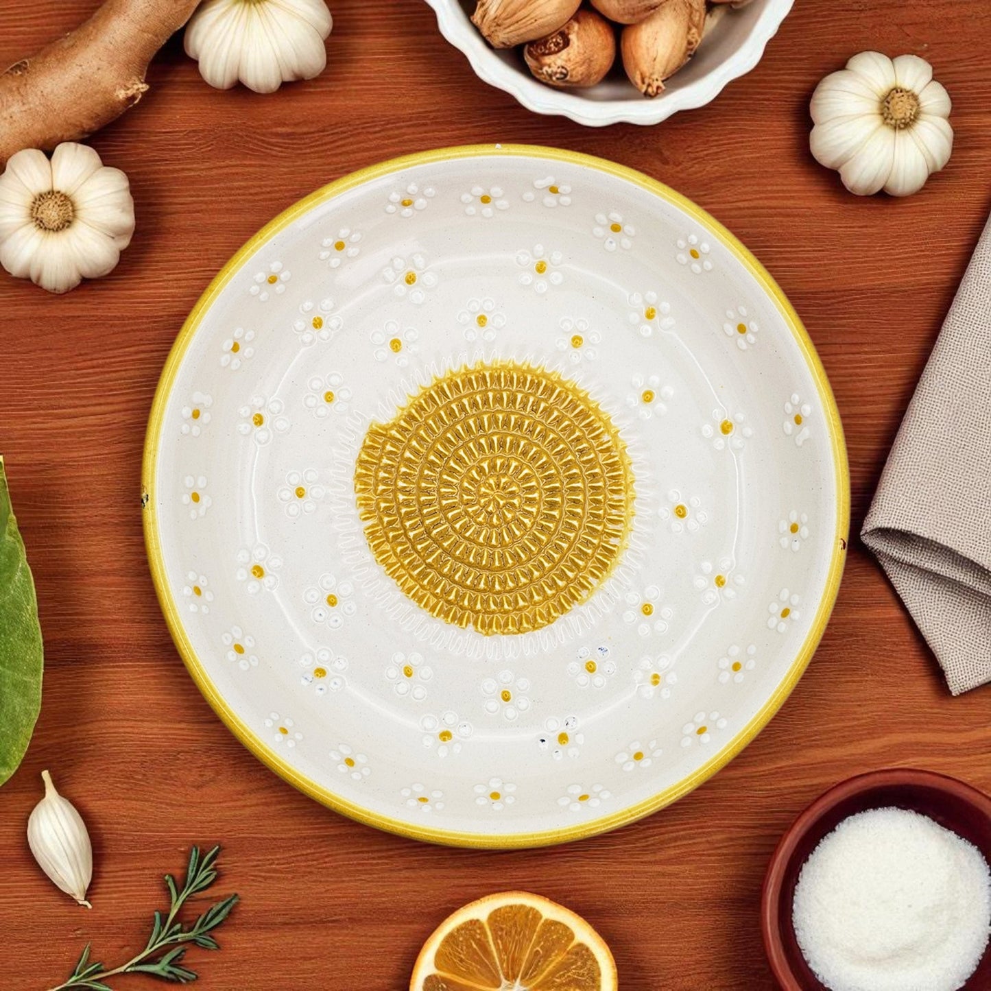 Decorative ceramic garlic grater bowl with yellow center and white rim on a wooden surface with autumn-themed items.