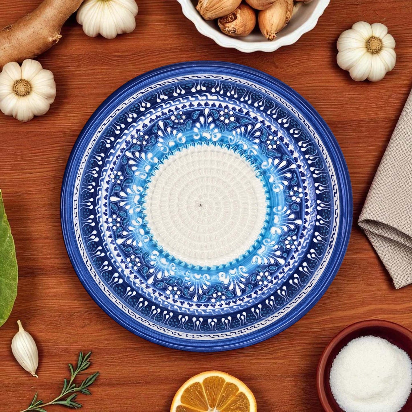 Decorative blue and white garlic grater bowl on a wooden table with autumn-themed items.