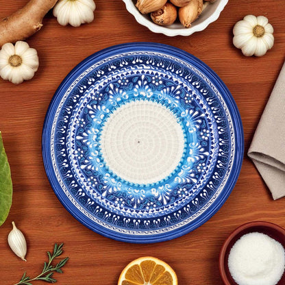 Decorative blue and white garlic grater bowl on a wooden table with autumn-themed items.