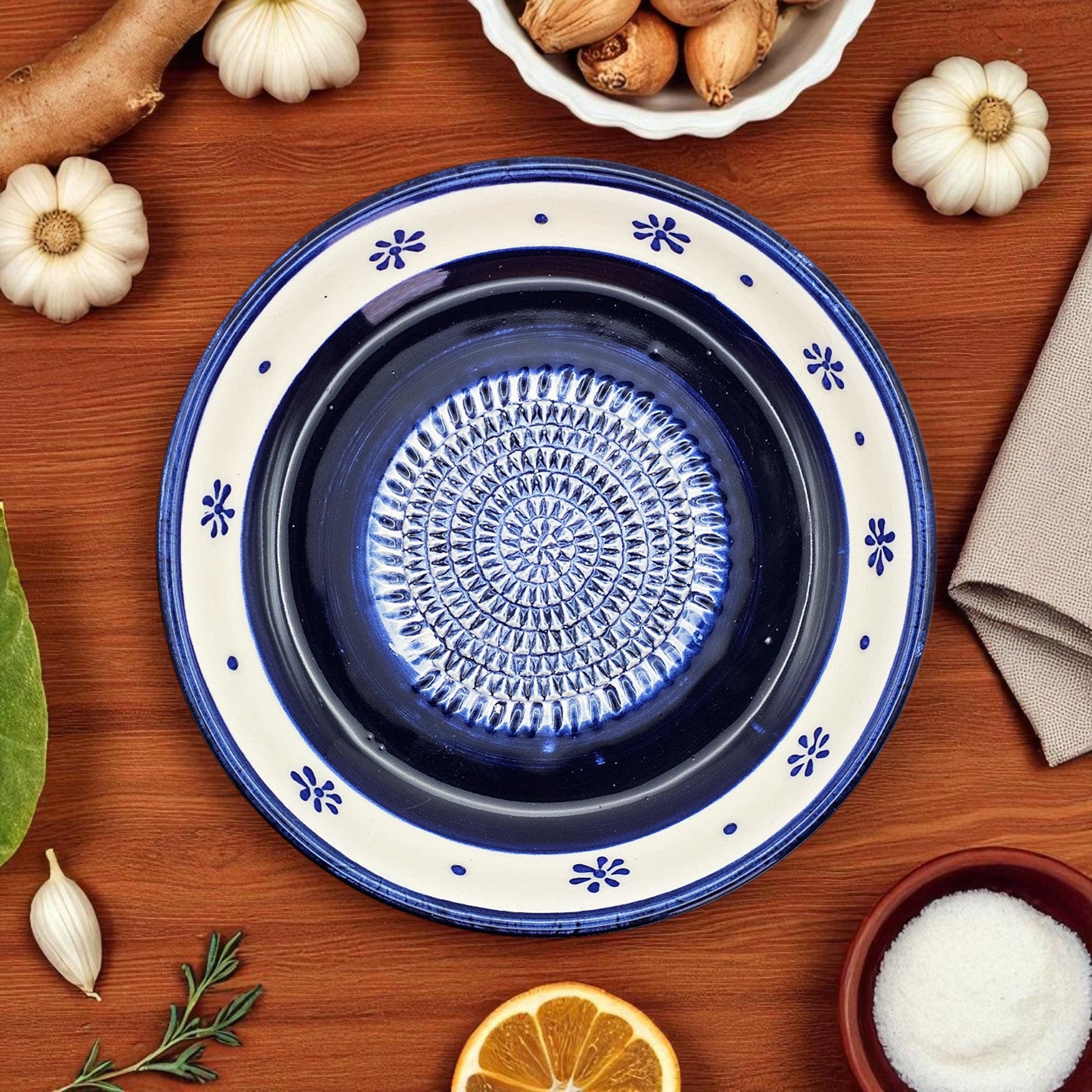 Decorative blue and white ceramic garlic grater bowl on a wooden surface with autumn-themed items.