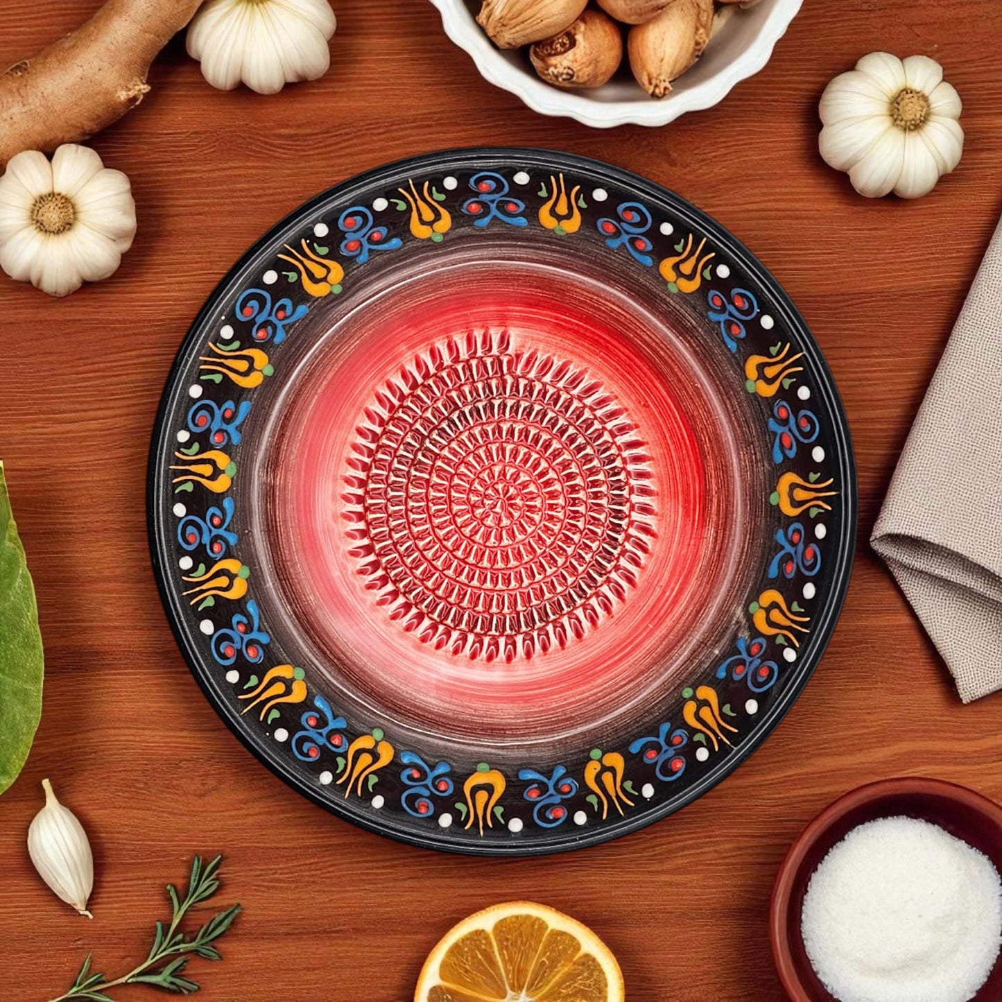 Decorative garlic grater bowl with colorful patterns on a wooden surface with ingredients.