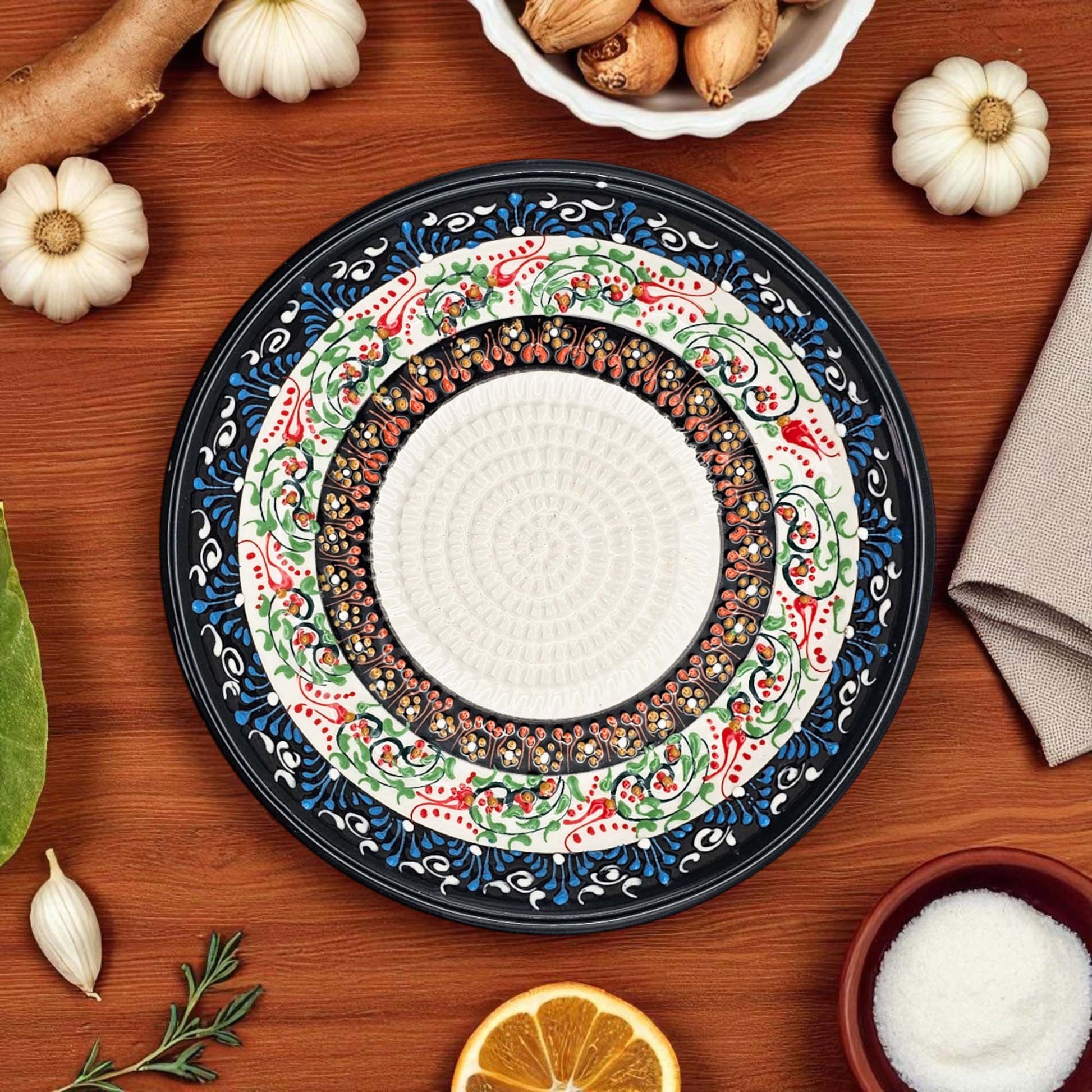 Decorative garlic grater bowl with intricate patterns on a wooden table with autumn-themed items.