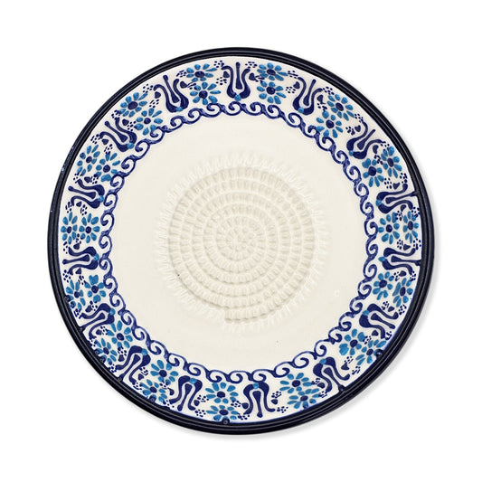 Decorative garlic grater plate with blue floral pattern on a white background