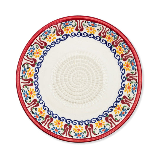 Decorative garlic grater bowl with colorful floral pattern on a white background