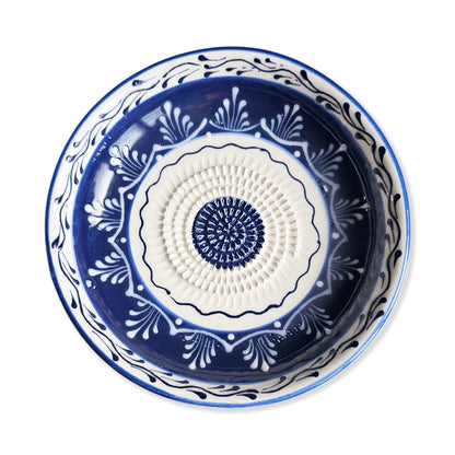 Decorative blue and white ceramic garlic grater bowl with intricate patterns on a white background