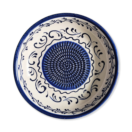 Ceramic garlic grater bowl with blue and white decorative patterns on a white background