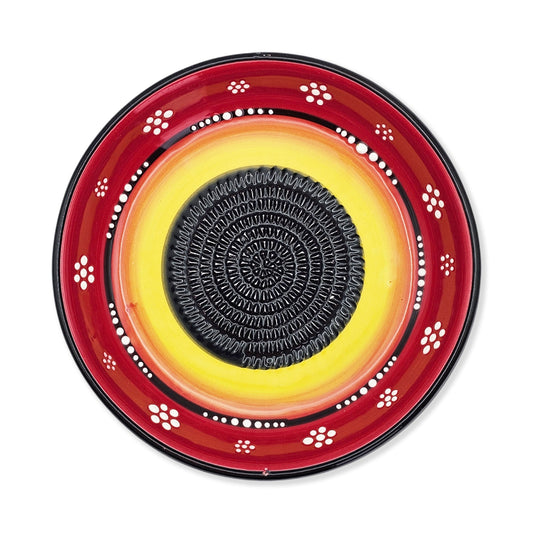Decorative garlic grater bowl with red, yellow, and black design on a white background