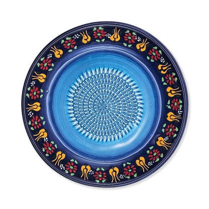 Decorative blue garlic grater bowl with floral patterns on a white background