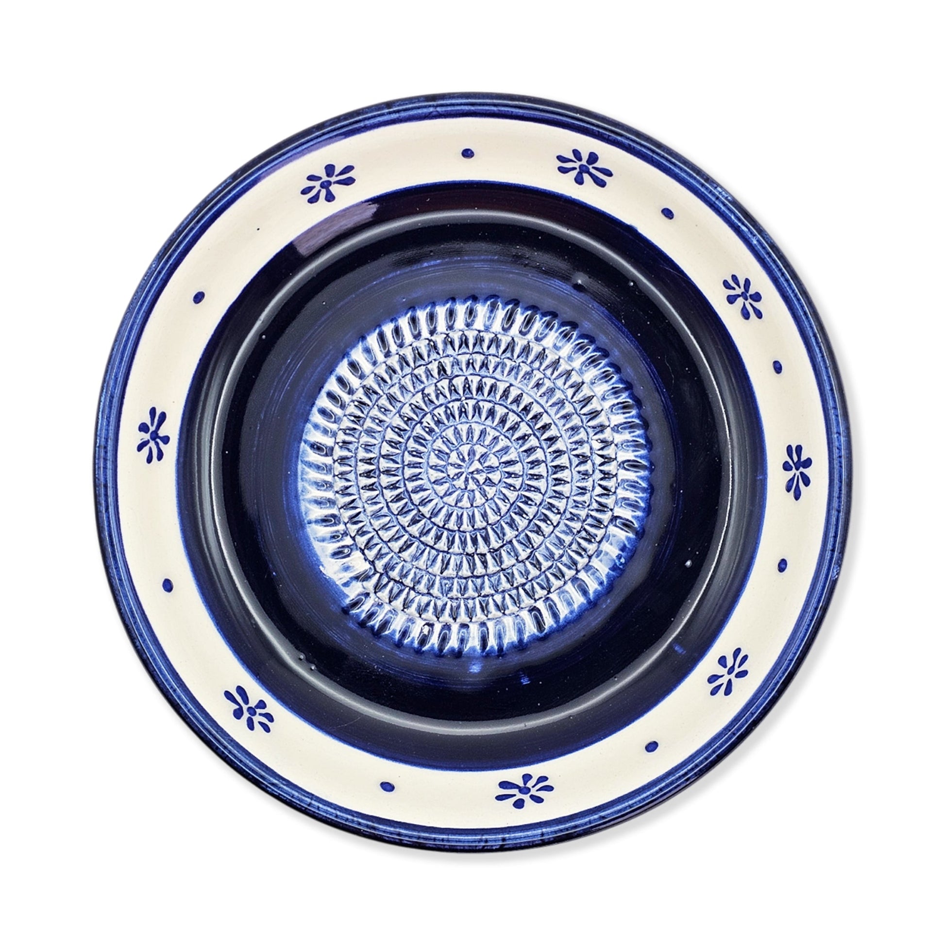 Ceramic garlic grater bowl with blue and white decorative rim on a white background