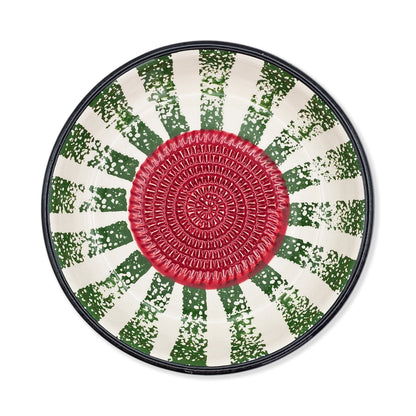 Round garlic grater bowl with a red center and green and white patterned rim on a white background