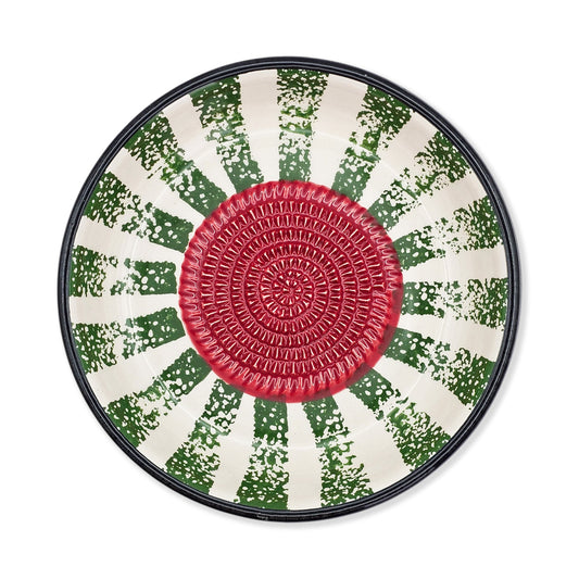 Round garlic grater bowl with a red center and green and white patterned rim on a white background