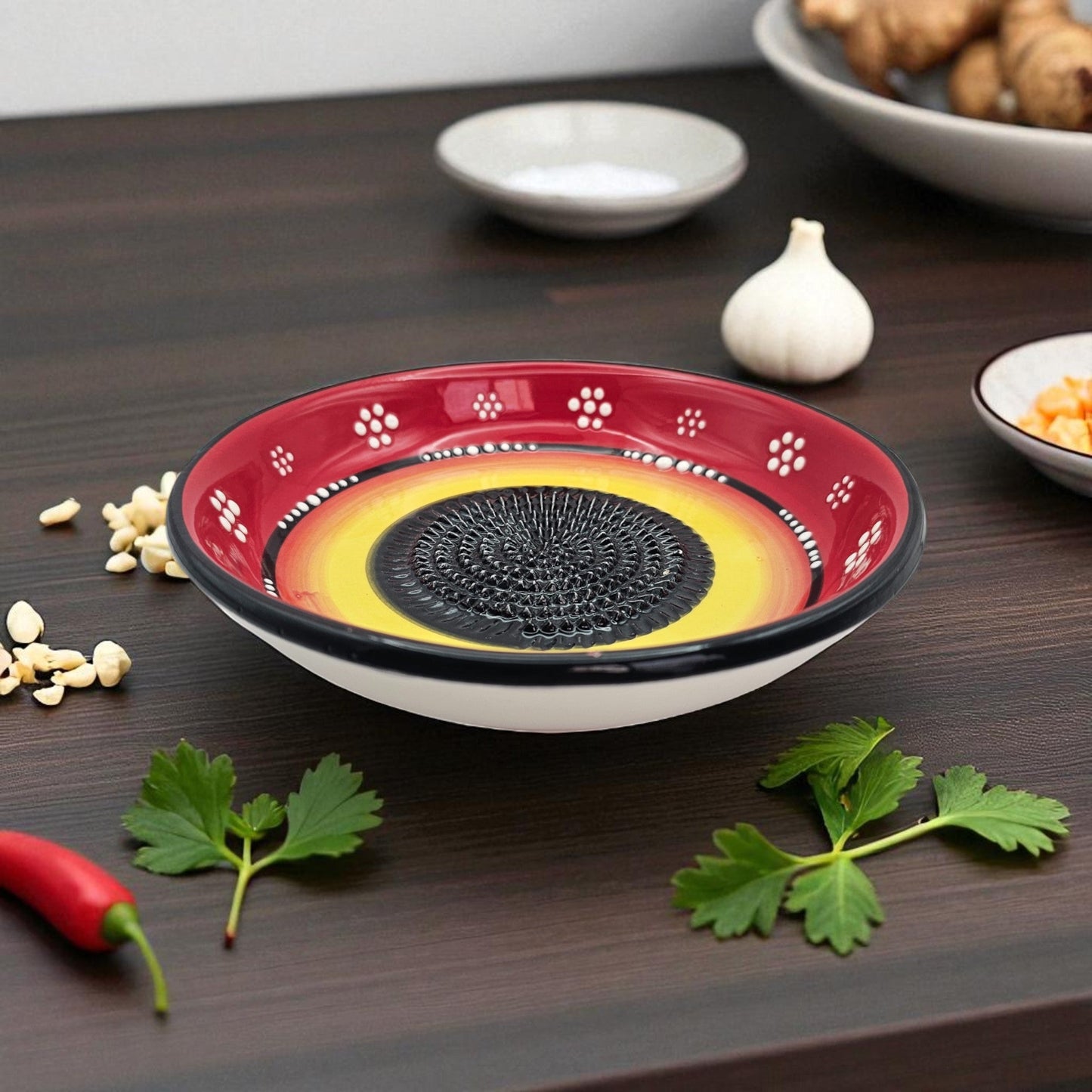 Decorative garlic grater bowl with a unique design on a wooden surface with herbs and spices.