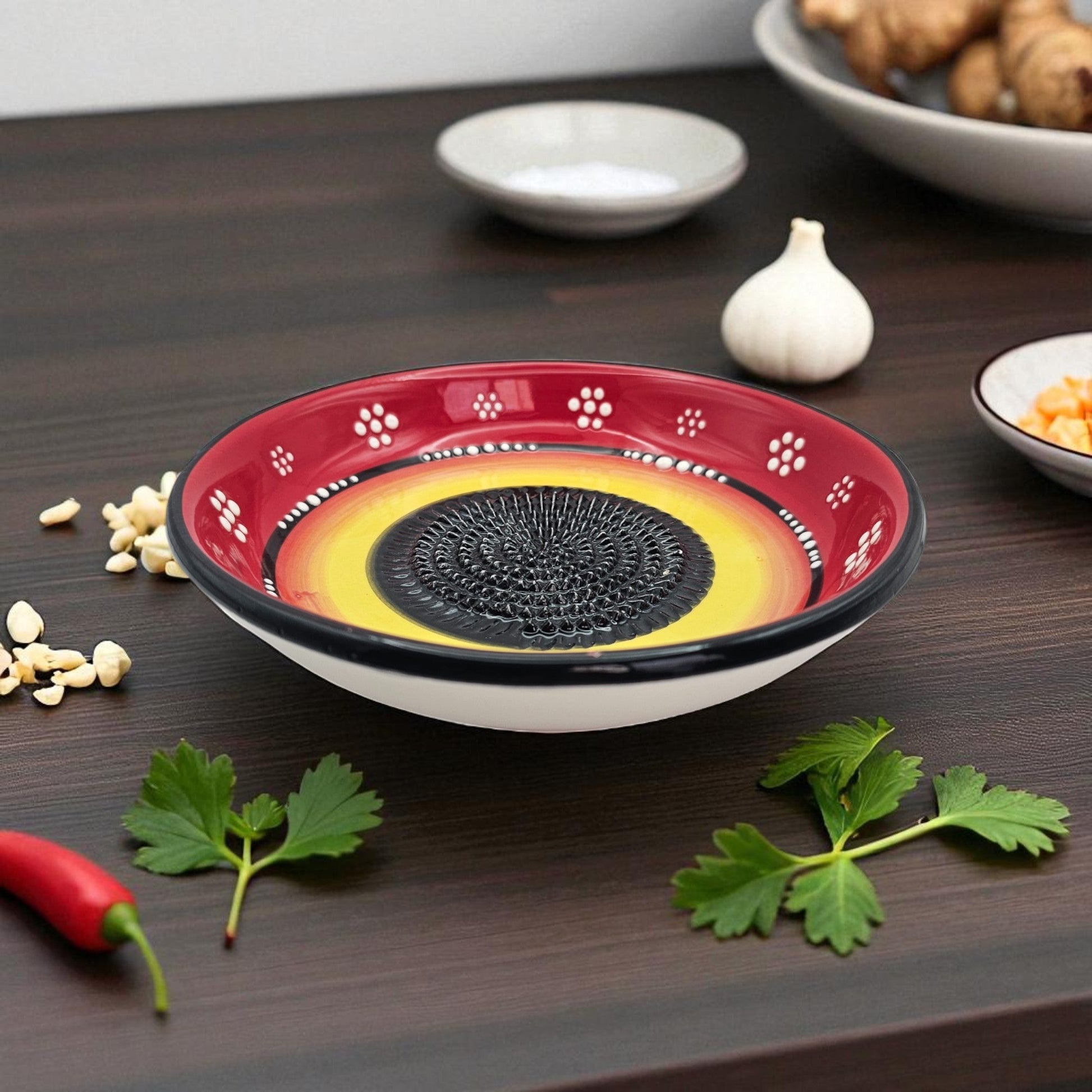 Decorative garlic grater bowl with a unique design on a wooden surface with herbs and spices.