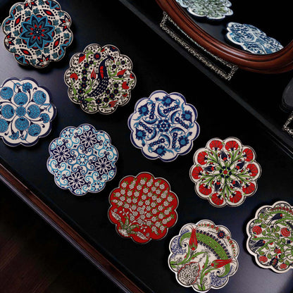 Decorative ceramic coasters with intricate designs on a dark surface.