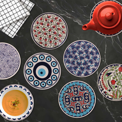 Collection of decorative ceramic trivets with various patterns on a dark surface.