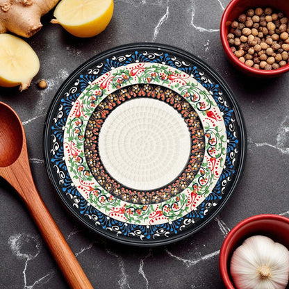 Decorative garlic grater bowl with intricate patterns on a dark surface with kitchen items.