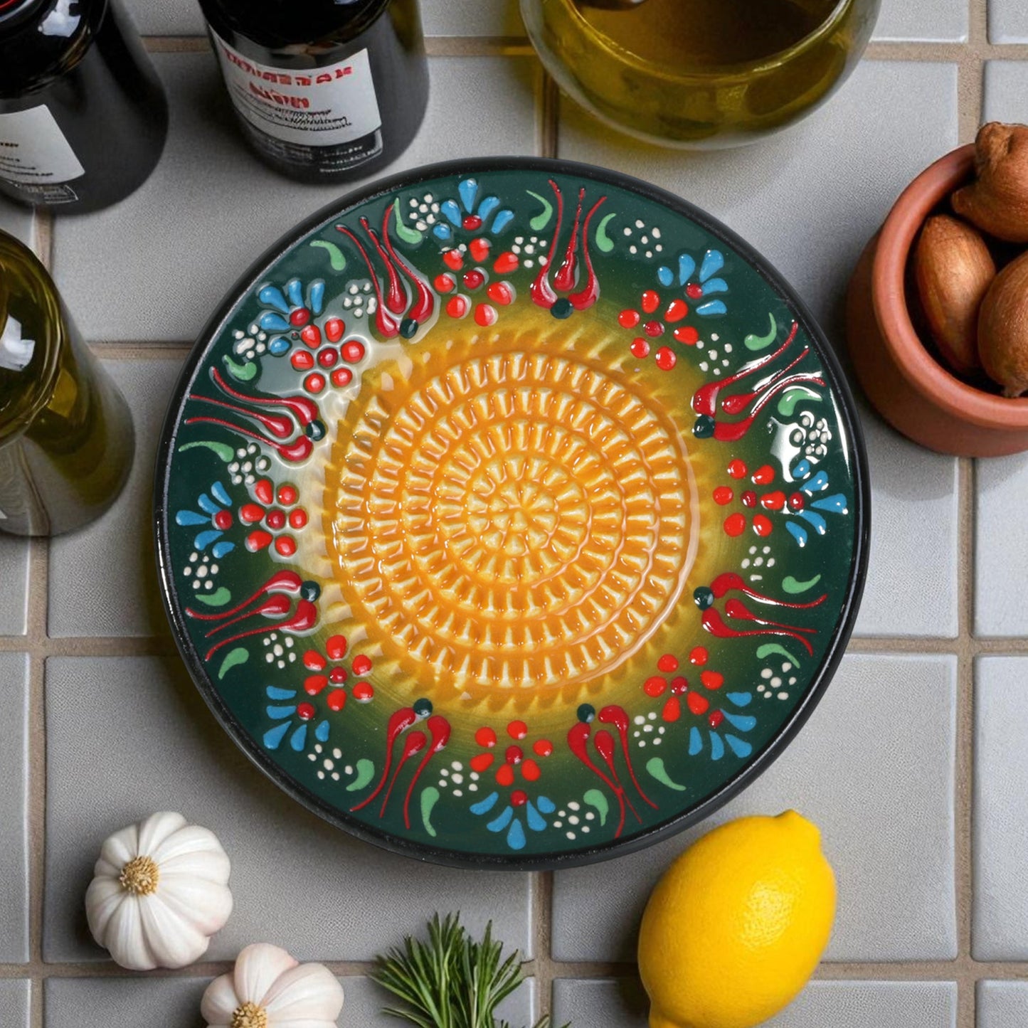Decorative ceramic garlic grater with floral patterns on a tiled surface with ingredients.