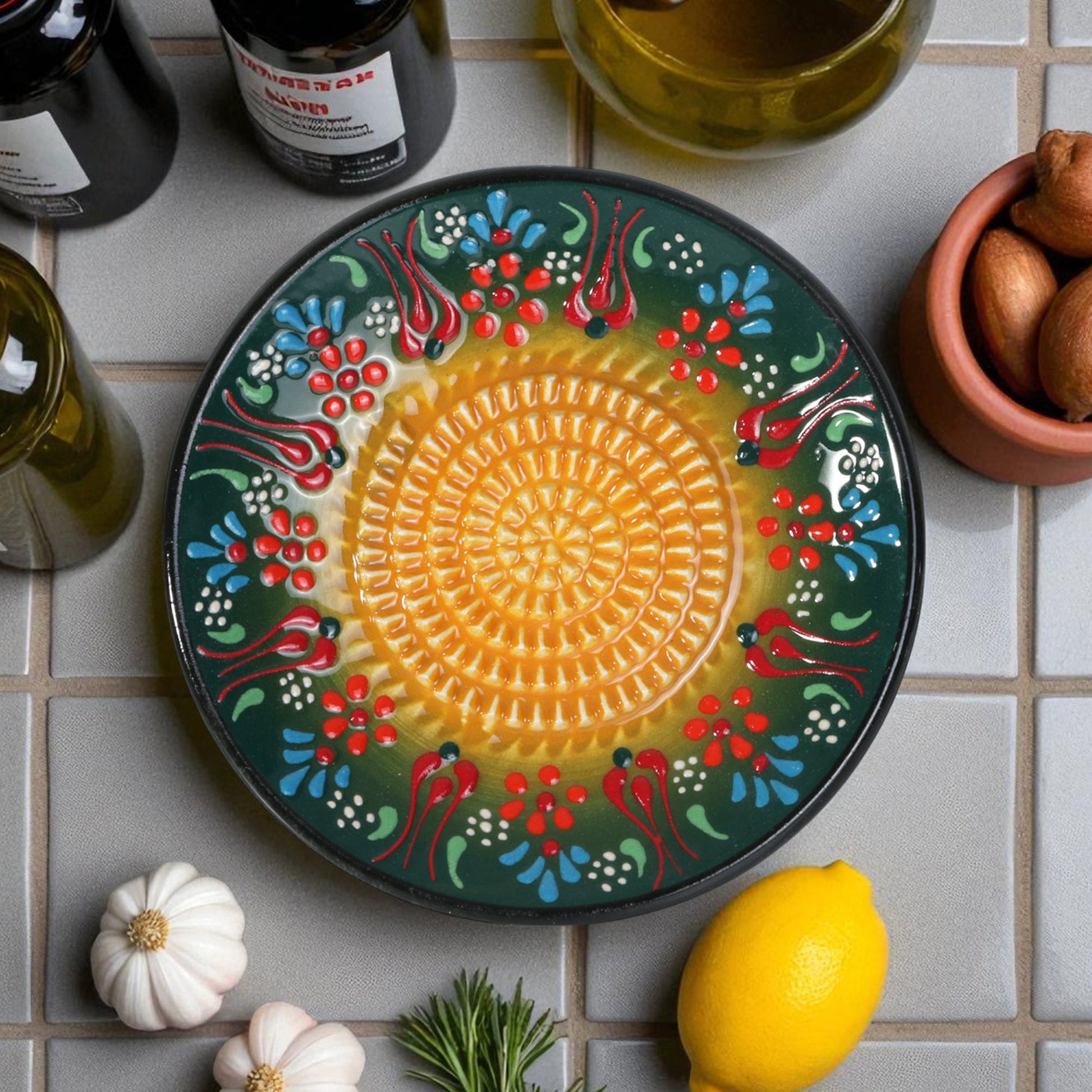 Decorative ceramic garlic grater with floral patterns on a tiled surface with ingredients.