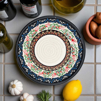 Decorative ceramic garlic grater bowl with intricate patterns on a tiled surface with ingredients.