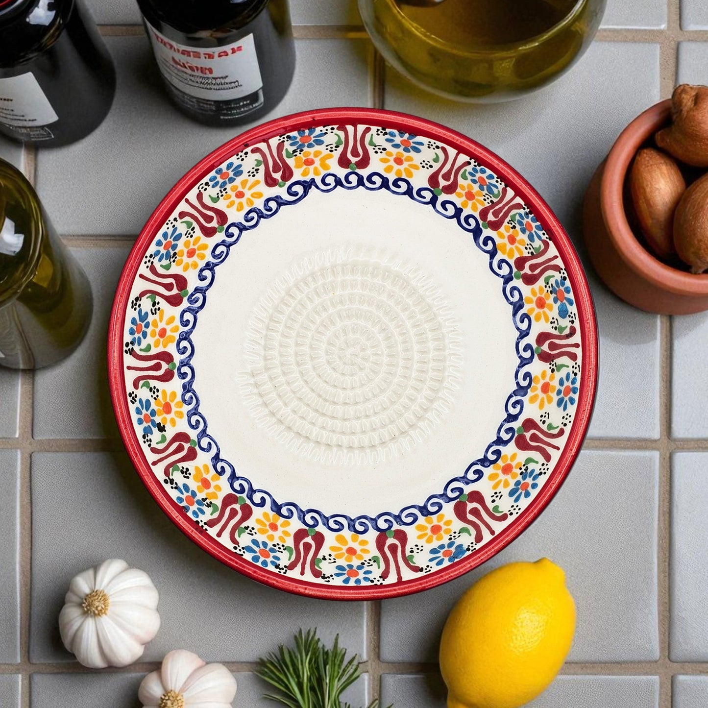 Decorative garlic grater bowl with colorful on a tiled surface with ingredients.