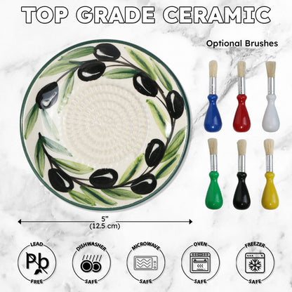 Ceramic garlic grater plate with olive design and optional brushes on a marble background