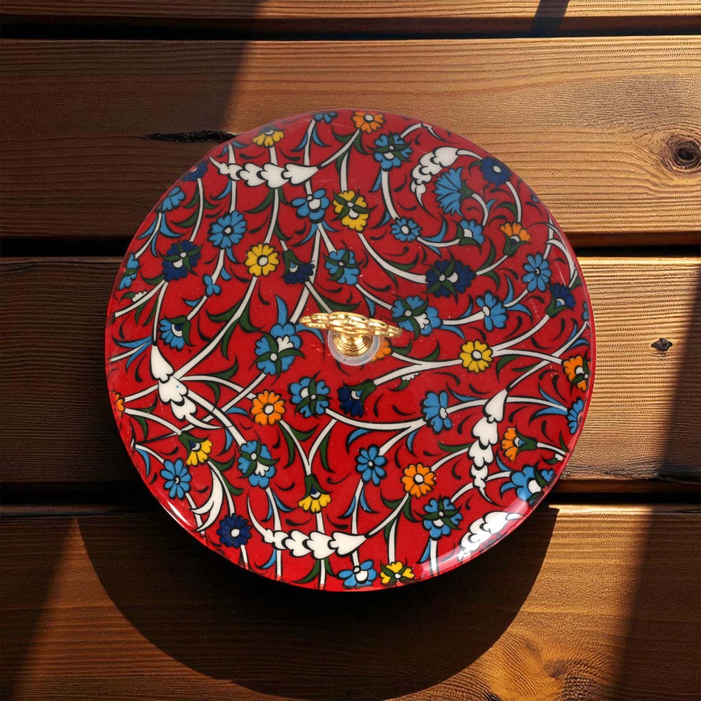 Decorative sugar bowl with floral pattern on a wooden surface