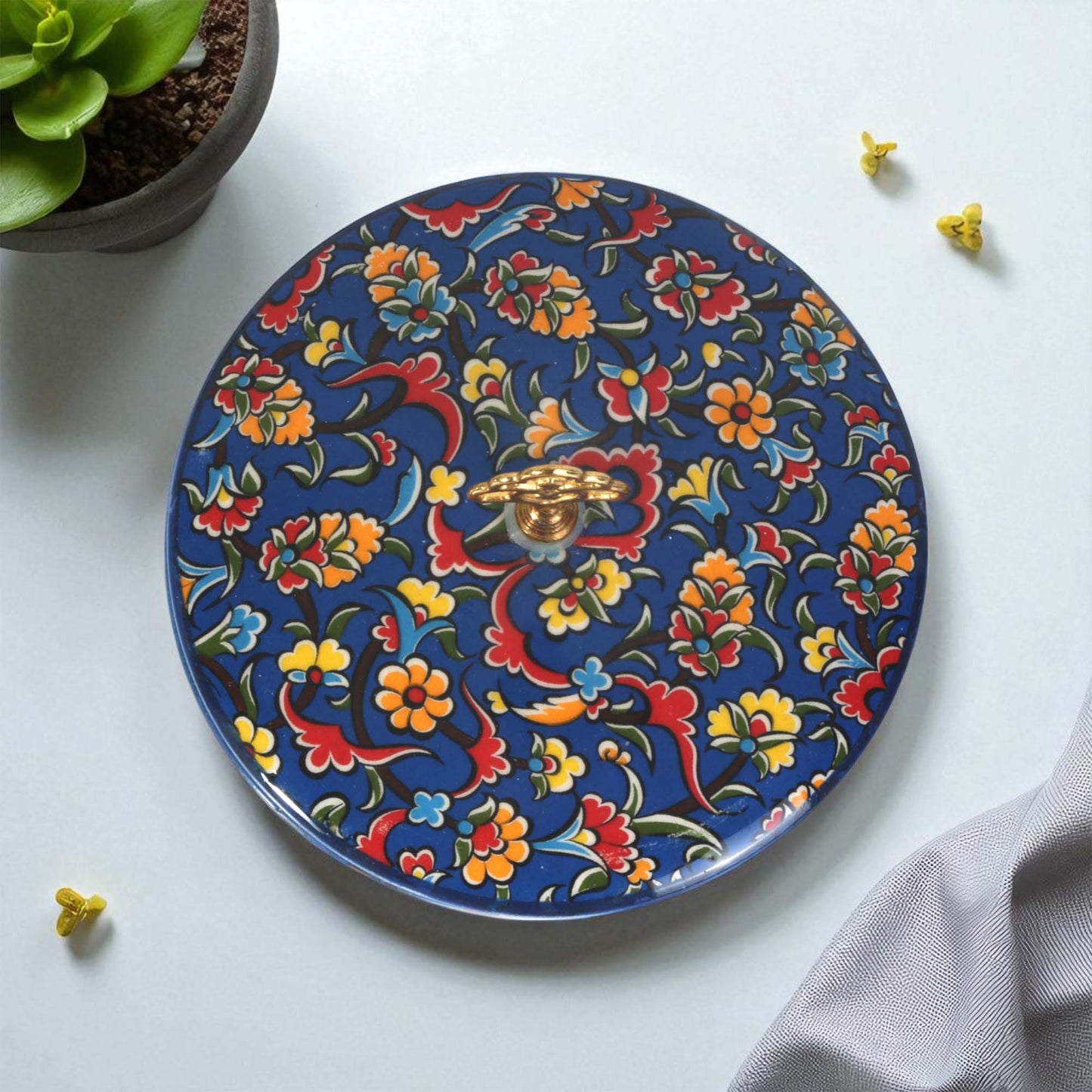 Decorative sugar bowl with colorful floral and dragon design on a white surface.