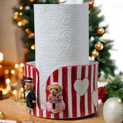 Decorative paper towel holder with teddy bears in front of a Christmas tree.