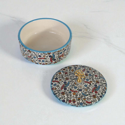 Decorative ceramic sugar bowl with floral pattern and lid on a white background