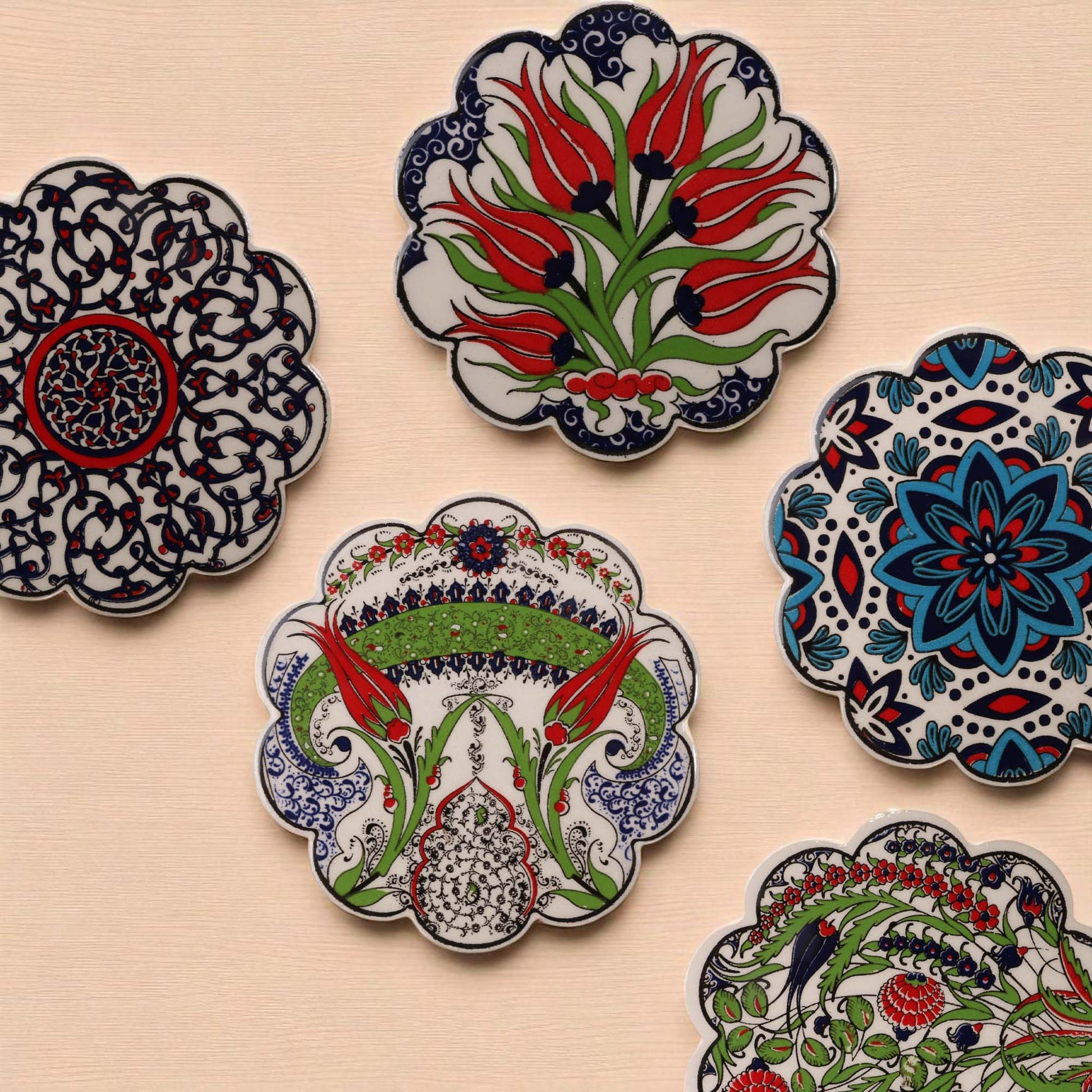 Decorative ceramic coasters with floral patterns on a beige surface